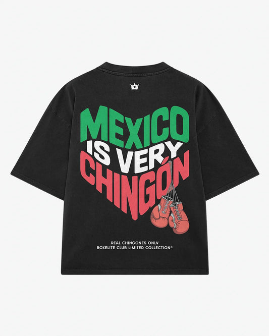 A black short-sleeve t-shirt with a large graphic on the back reading 'MEXICO IS VERY CHINGON' in green, white, and red lettering, accompanied by a graphic of red boxing gloves and small white text at the bottom.